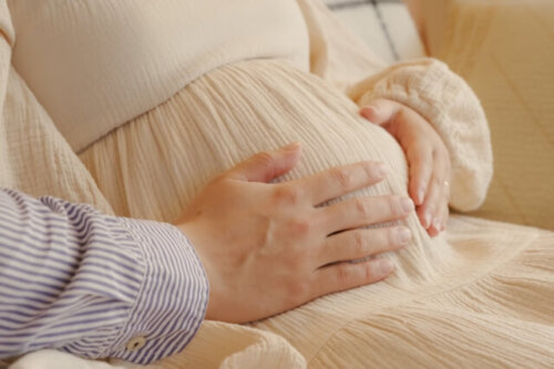 妊婦さんのお腹を支えるパパさん